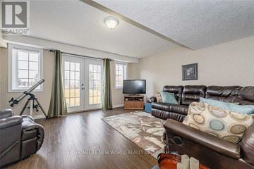 Guelph (Victoria North) townhouse for rent - A living room with a brown leather couch and a television.
