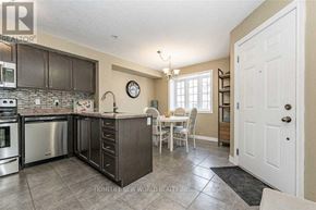 Guelph (Victoria North) townhouse for rent - A kitchen with a table and chairs in the middle of the room.