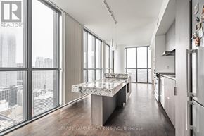 Toronto (Church-Yonge Corridor) condo for rent - A modern kitchen with a marble island and a view of the city.