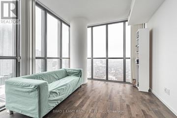 Toronto (Church-Yonge Corridor) condo for rent - A living room with a green couch and a view of the city.