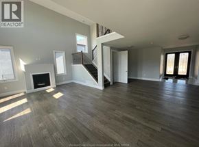 Amherstburg apartment for rent - A spacious living room with wood flooring and a staircase leading to the upper level.