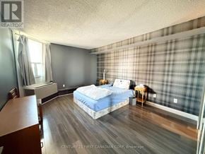 London East (East E) condo for rent - A bedroom with a bed, nightstand, and chair.