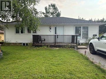 Barrie (Letitia Heights) apartment for rent - A white house with a black gate and a white car parked in front.