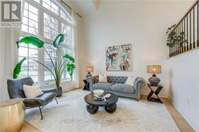 Burlington (Rose) apartment for rent - A living room with a grey couch, a coffee table, and a large window.