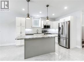 Azilda apartment for rent - A modern kitchen with a large island and stainless steel appliances.