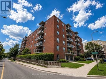 St. Catharines (Downtown) multi-family for rent - A tall red brick apartment building with balconies on the upper floors.