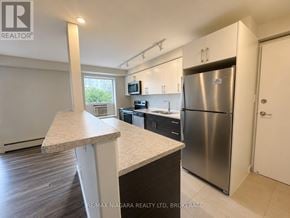 St. Catharines (Downtown) multi-family for rent - A kitchen with a refrigerator, microwave, and oven.