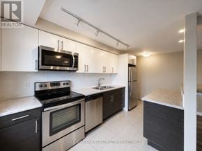 St. Catharines (Downtown) multi-family for rent - A modern kitchen with stainless steel appliances and dark wood cabinets.