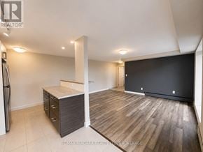 St. Catharines (Downtown) multi-family for rent - A spacious room with wooden flooring and a black wall.