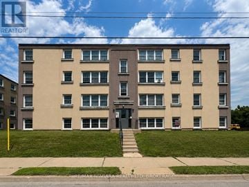 St. Catharines (E. Chester) multi-family for rent - A large apartment building with a green lawn in front.