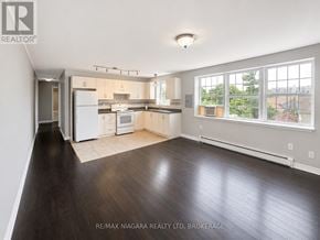 St. Catharines (E. Chester) multi-family for rent - A spacious kitchen and living room with hardwood floors and a large window.