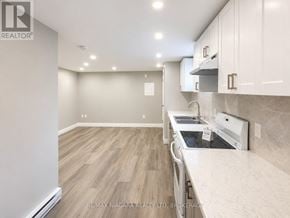 St. Catharines (E. Chester) multi-family for rent - A kitchen with a white counter top and wooden floors.