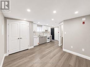 St. Catharines (E. Chester) multi-family for rent - A spacious kitchen with white cabinets and a wooden floor.