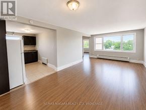 St. Catharines (E. Chester) multi-family for rent - A spacious room with wooden flooring and a large window.