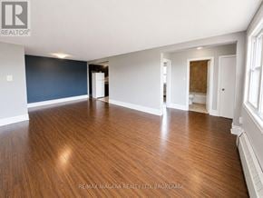 St. Catharines (E. Chester) multi-family for rent - A spacious room with wooden flooring and white walls.