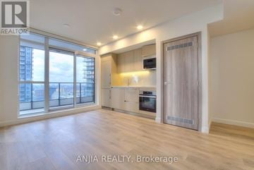 Toronto (Waterfront Communities) condo for rent - A spacious room with a kitchenette and a view of the city.