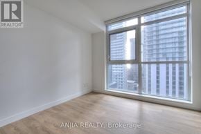 Toronto (Waterfront Communities) condo for rent - A room with a large window overlooking a cityscape.