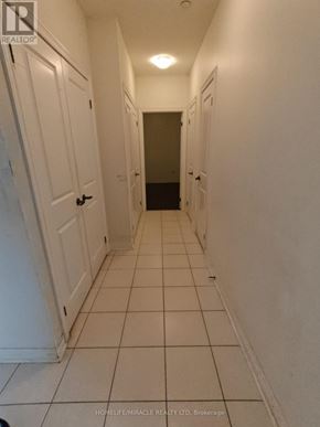 Markham (Cedarwood) condo for rent - A hallway with white doors and tiled floors.