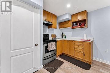 Brantford apartment for rent - A kitchen with wooden cabinets and a white door.
