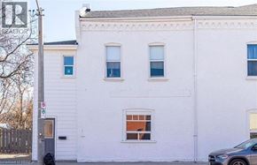 Brantford apartment for rent - A white building with a grey car parked in front.