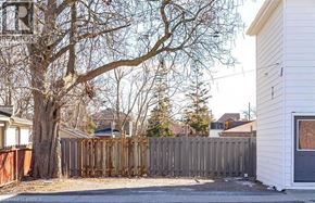 Brantford apartment for rent - A tree in front of a house with a fence.