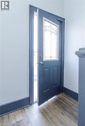 Brantford apartment for rent - A door with a glass window and a handle is closed.