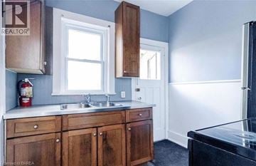 Brantford apartment for rent - A kitchen with wooden cabinets and a black counter.