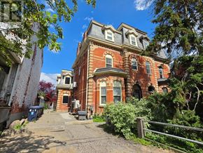 Toronto (Little Portugal) multi-family for rent - A large red brick building with a gated entrance.