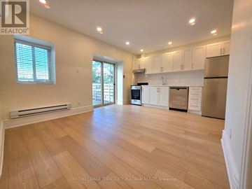 Toronto (Little Portugal) multi-family for rent - A spacious kitchen with white cabinets and stainless steel appliances.