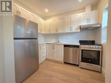 Toronto (Little Portugal) multi-family for rent - A kitchen with white cabinets and stainless steel appliances.