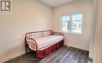 Richmond Hill (Headford Business Park) townhouse for rent - A bedroom with a red metal bed frame and a window.