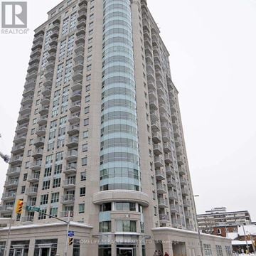 Ottawa condo for rent - A tall building with many windows and balconies is the main focus of the image.