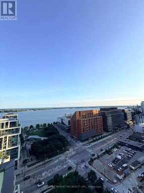 Toronto (Waterfront Communities) condo for rent - A view of a cityscape with a body of water in the background.