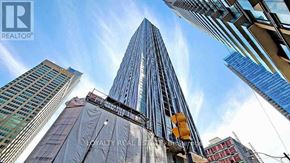 Toronto (Annex) condo for rent - A tall building under construction with a clear sky in the background.