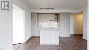 Toronto (Annex) condo for rent - A white room with a wooden floor and a white cabinet with a glass door.