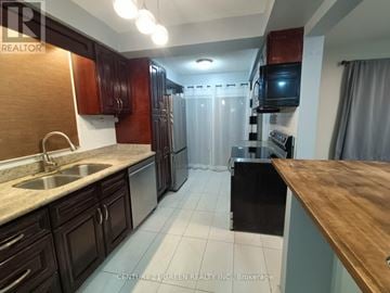 Ajax (Central West) apartment for rent - A kitchen with brown cabinets and a wooden countertop.