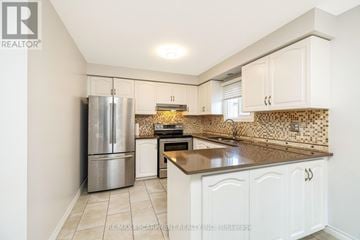 Mississauga (Lisgar) apartment for rent - A kitchen with white cabinets and a tiled backsplash.