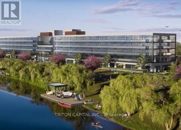 Welland (Broadway) condo for rent - A modern building complex with a body of water in front and a boat docked at the dock.
