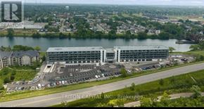 Welland (Broadway) condo for rent - A large building with a parking lot in front of it is labeled Triton Capital Inc., Brokerage.