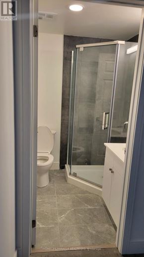 Brantford condo for rent - A bathroom with a toilet, sink, and shower.