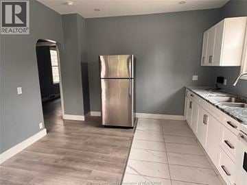 Windsor apartment for rent - A kitchen with a stainless steel refrigerator and white cabinets.