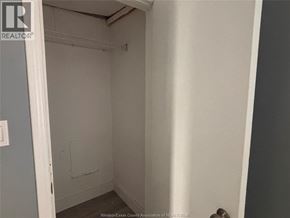 Windsor apartment for rent - A small, empty room with a door on the left and a wall on the right.