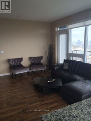 Toronto (Niagara) condo for rent - A living room with a black couch and two purple chairs.