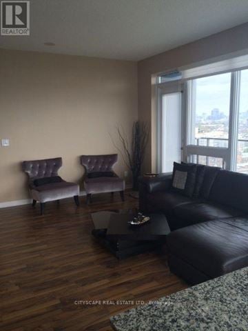 Toronto (Niagara) condo for rent - A living room with a black couch and two purple chairs.