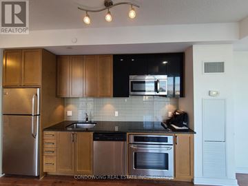 Toronto (Mount Pleasant East) condo for rent - A kitchen with wooden cabinets and stainless steel appliances.