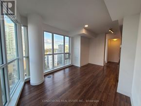 Toronto (Mount Pleasant East) condo for rent - A room with wood flooring and a large window overlooking a cityscape.