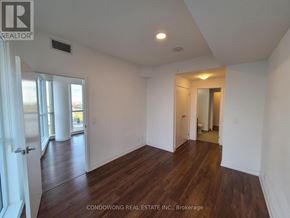 Toronto (Mount Pleasant East) condo for rent - A room with wood flooring and white walls, with a door on the left and a hallway on the right.