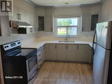 Markham (Old Markham Village) apartment for rent - A kitchen with a black stove top oven and a black refrigerator.