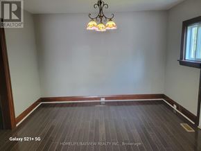 Markham (Old Markham Village) apartment for rent - A room with a chandelier and a window with a view of a building outside.