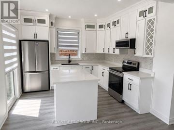 Barrie (Innis-Shore) apartment for rent - A kitchen with white cabinets and appliances.